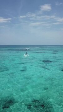 Vertical Aerial view of Boat ryding in Tankah Bay, Tulum, Mexican Caribbean