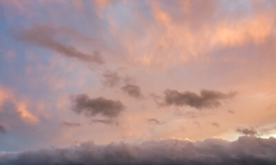 Obraz premium A beautiful sky tinted by the sun leaving vibrant shades of gold, pink, blue and multicolored. Clouds in the twilight evening and morning sky. Cloudy sky background in the evening, and during the day.