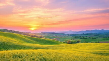 Obraz premium A serene countryside sunset with rolling green hills, golden fields, and a vibrant sky of pink and orange hues.