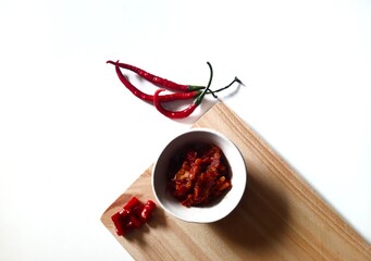 Sambal or Indonesian traditional chili sauce. Served in a small bowl on cutting board