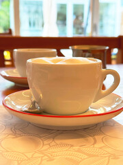 Cozy morning coffee with frothy cappuccino in bright café setting