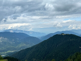 Scenic mountain landscape with lush green forests and majestic cloudy sky