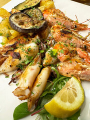 Grilled seafood platter with shrimp, squid, and vegetables garnished with lemon