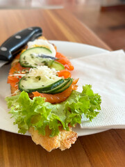 Gourmet smoked salmon baguette with fresh vegetables and creamy cheese