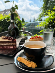 Outdoor coffee and dessert setting with chocolate cake and eclair