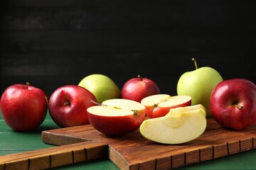 Fresh ripe apples on green wooden table