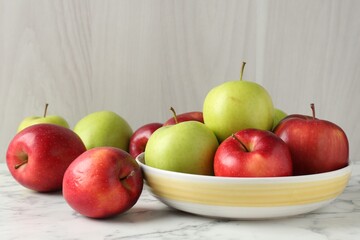 Ripe red and green apples on white marble table