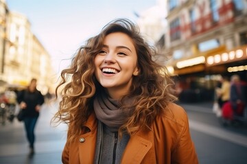 Portrait of a beautiful young woman laughing on the street at sunset