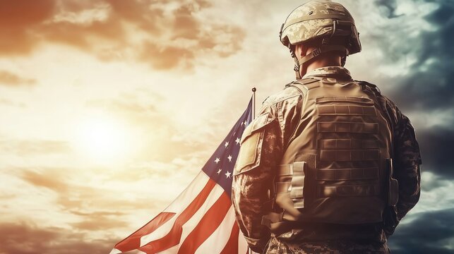The powerful back view of an American soldier stands proudly with a waving flag against a bright sunny sky, embodying a strong military theme. Dressed in a military uniform and helmet, the soldier rep