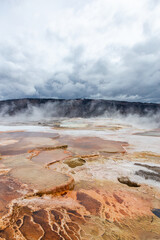 Majestic Geothermal Landscape in Yellowstone National Park, Wyoming, USA with Steaming Hot Springs and Dramatic Cloudy Sky