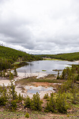 Fototapeta premium Serene Landscape View of Yellowstone Lake and Forested Hills in Wyoming, USA on an Overcast Day