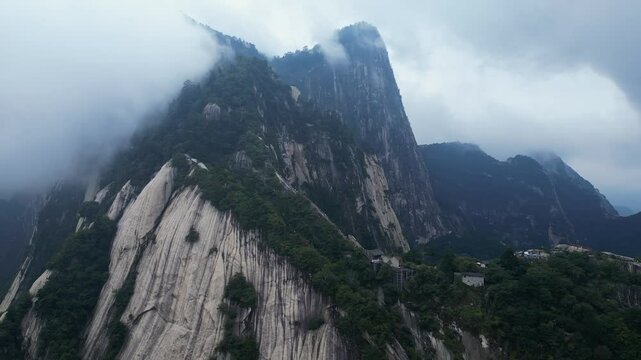 Huashan, China: Aerial drone footage of the dramatic Mt Huashan near Xi'an in Shaanxi in central China with atmospheric mist and fog. 