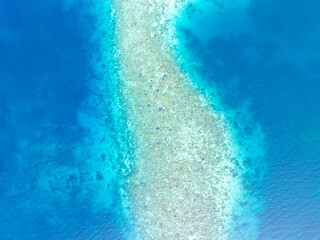A beautiful and healthy coral reef surrounds a volcanic island off the coast of Flores, Indonesia. This area, in the Lesser Sunda Islands, is known for its high marine biodiversity.
