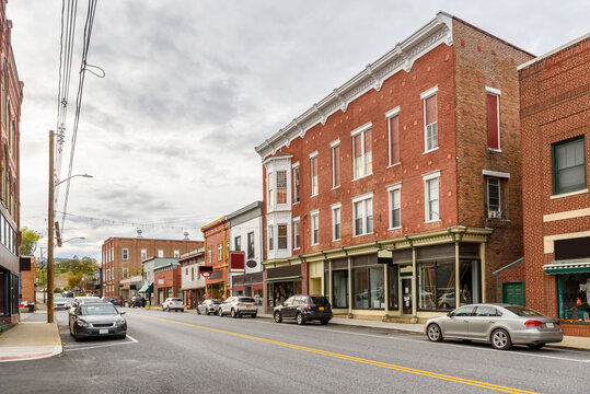 Traditional American brick buildings with shops along a street in a historic downtown district on a cloudy fall day