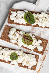 Homemade crispy toasts with ricotta, cottage cheese and herbs, 
microgreens, healthy eating, food for athletes