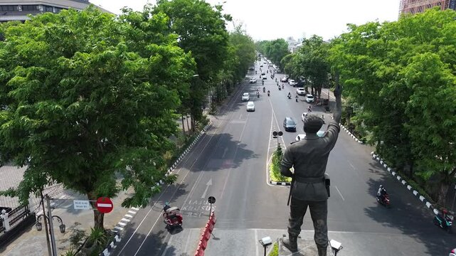 The atmosphere of Surakarta's Slamet Riyadi street and the monument statue is visible, aerial drone, footage city, Indonesia