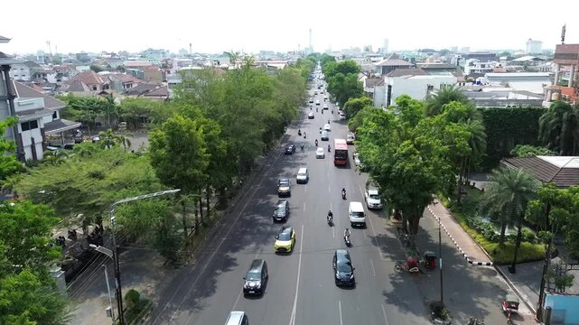 The atmosphere of Surakarta's Slamet Riyadi street and the monument statue is visible, aerial drone, footage city, Indonesia