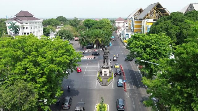 The atmosphere of Surakarta's Slamet Riyadi street and the monument statue is visible, aerial drone, footage city, Indonesia