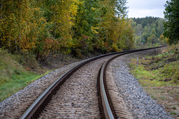 Railway tracks curve through the autumn forest