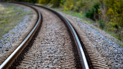 Fototapeta premium Railway tracks curve through the autumn forest