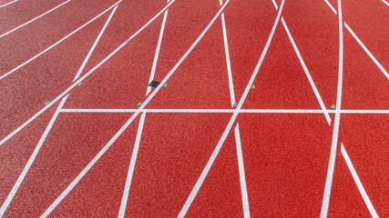 Aerial image of a new red running track with white lane lines and other markings.	