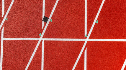 Aerial image of a new red running track with white lane lines and other markings.	