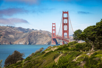A stunning view of the Golden Gate Bridge surrounded by lush greenery and the calm waters of the San Francisco Bay.