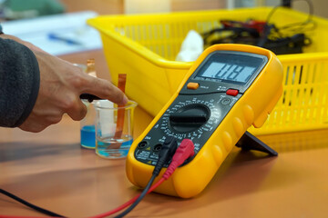 Students use a digital multimeter to measure electrical potential differences in a chemistry...