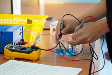 Students use a digital multimeter to measure electrical potential differences in a chemistry...