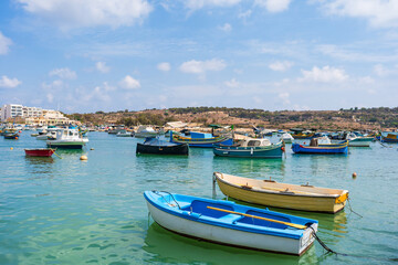 View of Marsaxlokk harbour with traditional colourful fishing boats in Malta