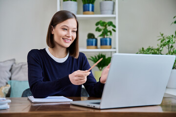 Young female college student studying using laptop computer for video chat