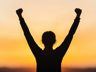 Fototapeta premium Silhouette of a person celebrating against a vibrant sunset, embodying triumph and joy in a moment of success.