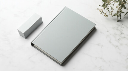 Closed book with sleek minimalist cover, product shot next to it, marble tabletop, clean white background, subtle shadows, space for text in the background, high-res