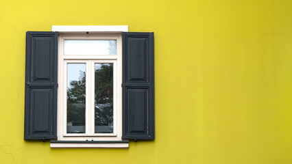 Open wooden shutters on yellow wall. Rustic background idea concept. Wooden window village cottage house.	