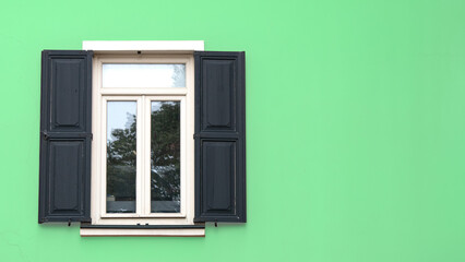 Wooden window village cottage house. Open wooden shutters on green wall. Urban background idea concept.	