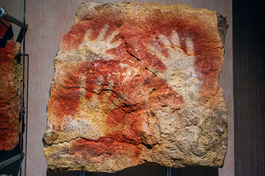 Cantabria, Spain - July 21, 2024:   Rock paintings at the replica of ancient Altamira cave at Santillana del Mar in Spain. Famous hand imprints