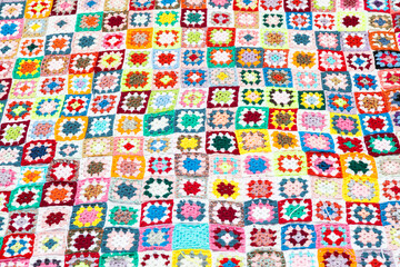 Fototapeta premium Multi colored blanket in wool, square geometric background, retro decorative pattern