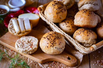 Homemade rye buns on a wooden table. Rye buns with flax seeds in a basket. Close-up