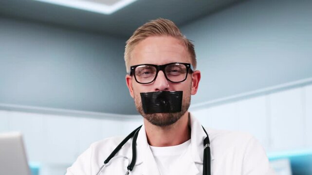 Medical Doctor With Black Duct Tape Over His Mouth