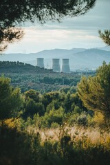 Naklejka premium Distant view of a nuclear power plant with cooling towers and reactors