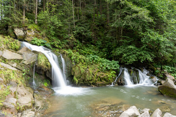 Mountain waterfall in the forest. Green nature. Lake water Kamianka in the Ukrainian Carpathians river