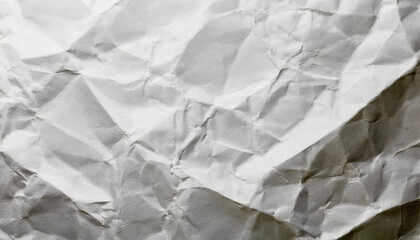 Crumpled white paper texture showing intricate creases and shadows in natural light during daytime