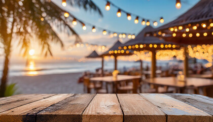 Sunset over beachfront dining with string lights illuminating wooden tables at a tropical resort in the evening