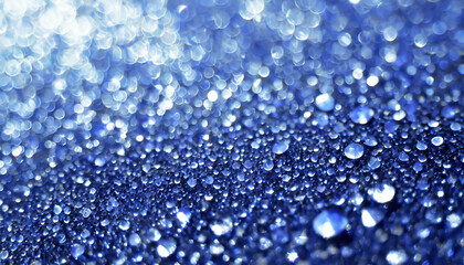 Close-up view of shimmering water droplets on a blue surface under soft light creating a mesmerizing sparkling effect