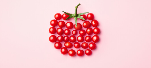 A single cherry tomato composed of small tomatoes on a pink background