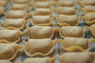 Surowe pierogi, ręcznie robione, przygotowane do gotowania. Polska tradycyjna potrawa wigilijna. Pierogi ruskie z ziemniakami i serem. 