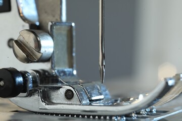 Sewing machine on light grey background, macro view