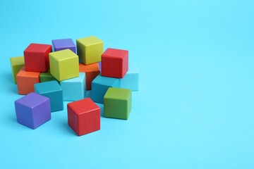 Obraz premium Many colorful cubes on light blue background. Space for text