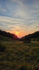 Beautiful sunset in the mountains, green forest red sunset
