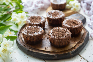 Chocolate mini cheesecakes on a wooden board. Cheesecakes for breakfast. Close-up.